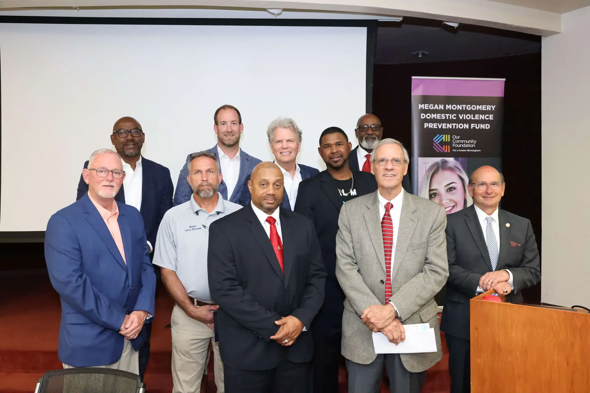 AMEND Together Executive Director Shan Foster stands with central Alabama mayors present at the meeting.